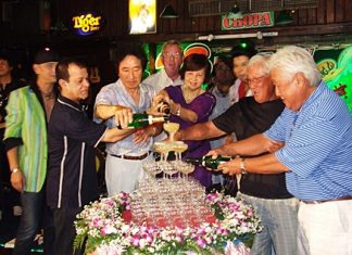 Diana Group Managing Director Sopin Thappajug, center, helps start the champagne waterfall as part of the 23rd anniversary celebrations for the Green Bottle Pub.